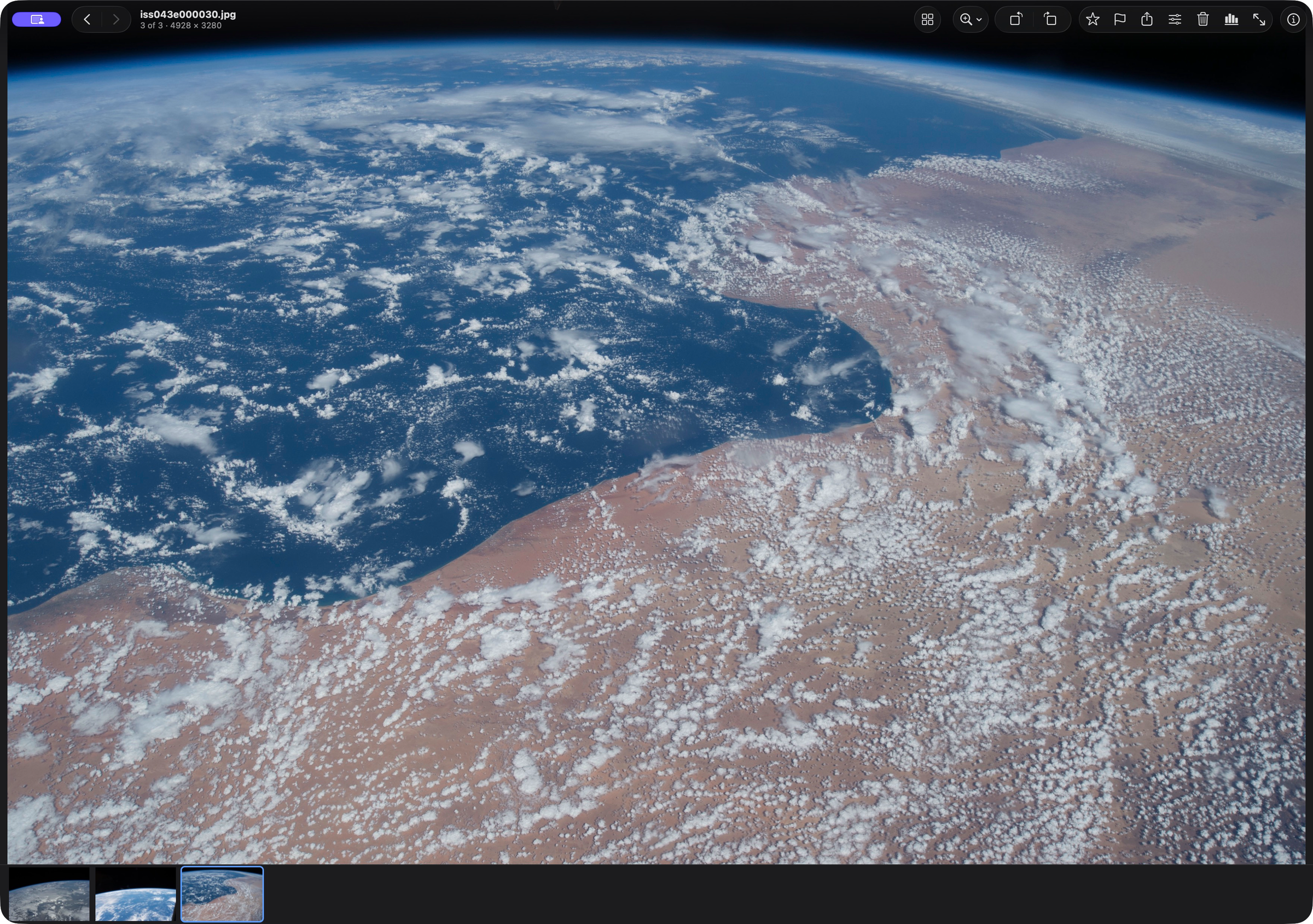 Earth and clouds in Shrike’s viewer, with three photos in the filmstrip.
